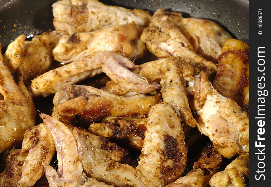Fried delicious chicken wings on the frying pan