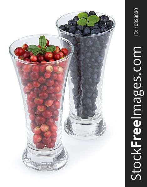 Bilberries and cranberries in glass on white background. Bilberries and cranberries in glass on white background.