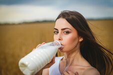 Beautiful Woman Is Drinking Beautiful Woman Drinking Milk In Countryside Field Looking At Camera. Close-up To Very Bin Countryside Stock Images