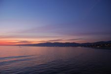 Sunset On The Beach With Mountains And City Royalty Free Stock Images