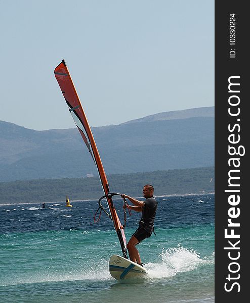 A front picture of a man, surfing @ Zlatni Rat beach, Brac island, Croatia. A front picture of a man, surfing @ Zlatni Rat beach, Brac island, Croatia