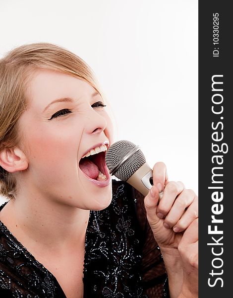Young fun and bubbly woman sings into microphone with fervour. Young fun and bubbly woman sings into microphone with fervour