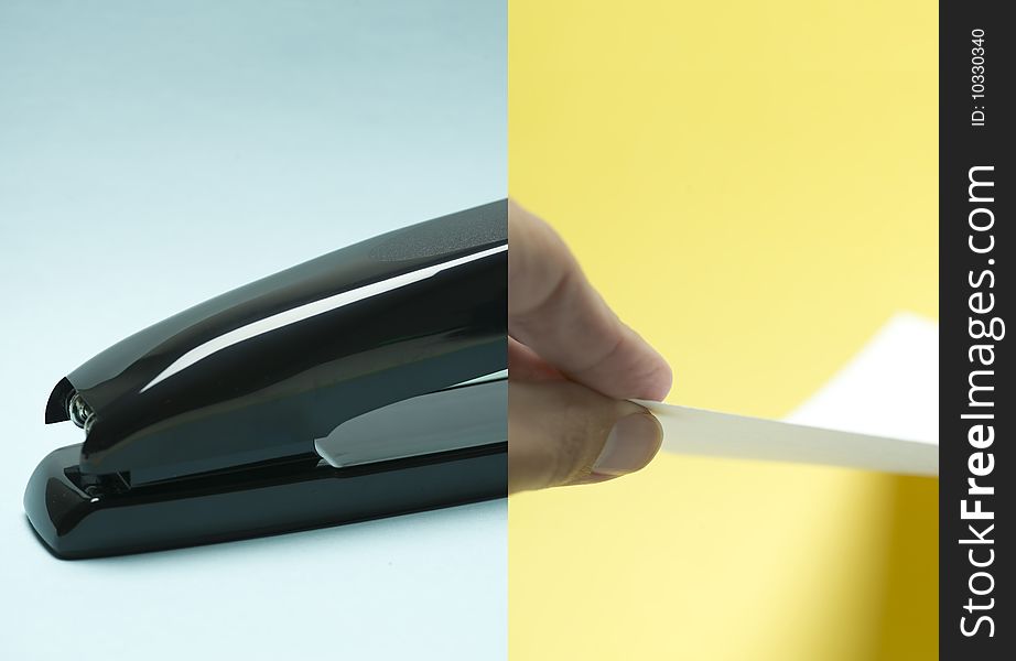 Merged image of a stapler and a hand holding a piece of paper. Merged image of a stapler and a hand holding a piece of paper