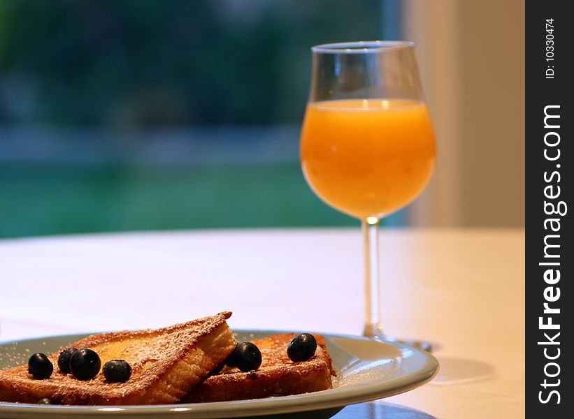 Fluffy french toast with powdered sugar, blueberries, and orange juice. Fluffy french toast with powdered sugar, blueberries, and orange juice