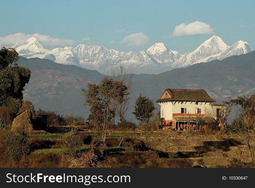 Traditional Nepali house with the central Himalayas in the background, Kathmandu, Nepal. Traditional Nepali house with the central Himalayas in the background, Kathmandu, Nepal