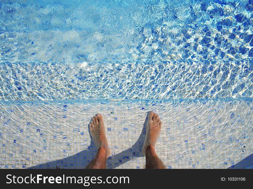 Feet in the water of a swimming pool