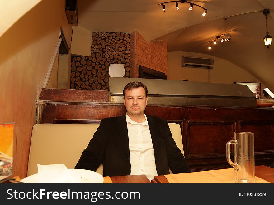 The man poses after dinner in a restaurant. The man poses after dinner in a restaurant