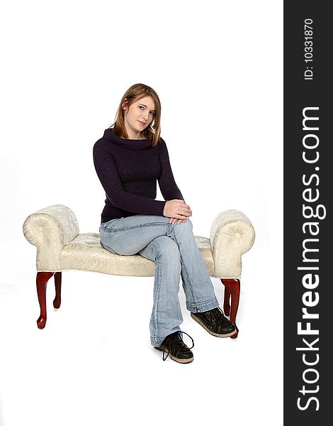 Sweet looking teenage girl sitting on white bench