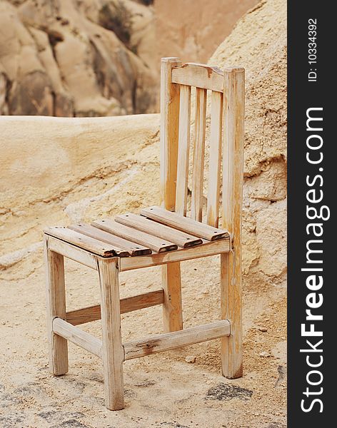 Yellow aged chair on natural rock background. Yellow aged chair on natural rock background