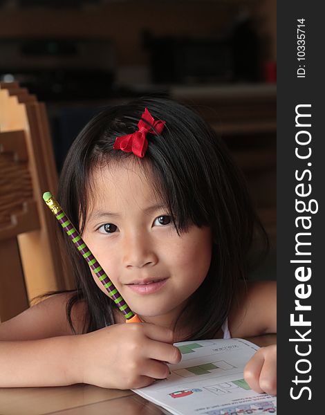 Portrait of cute young Asian girl writing with colorful pencil. Portrait of cute young Asian girl writing with colorful pencil.