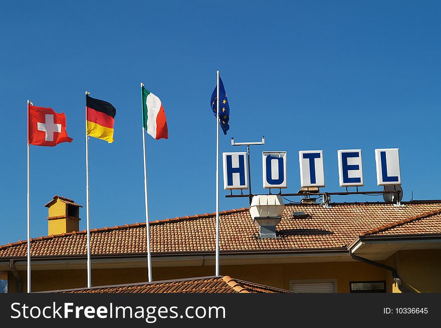Hotel roof with sign and national flags. Hotel roof with sign and national flags