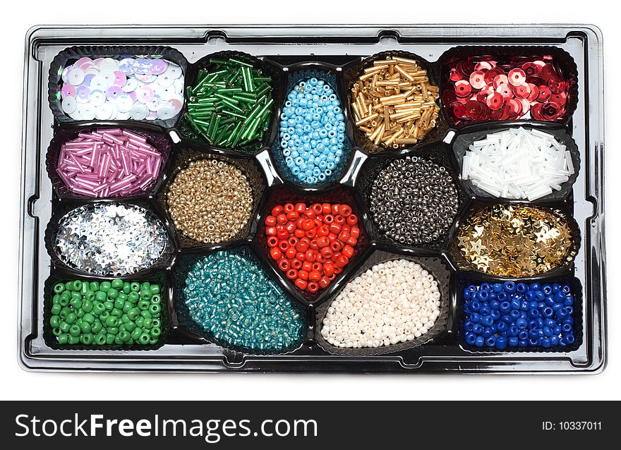 Colour beads in form under sweetmeats on white background