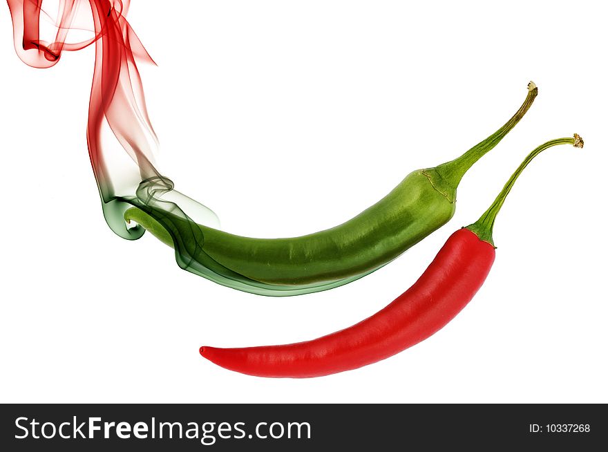Red and green hot chili pepper with color smoke on white