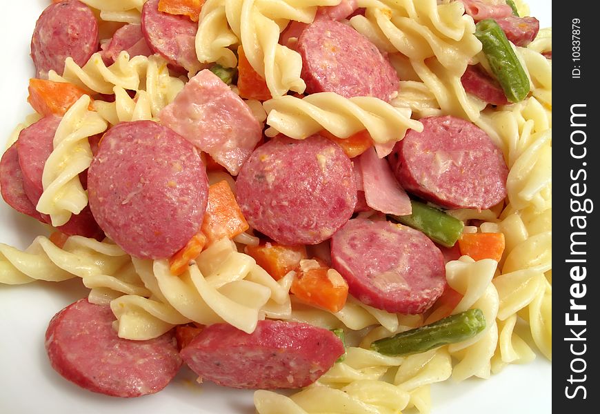 Photo of Italian fusilli pasta served with sliced beef hot dogs, ham slices, carrots and string beans. Cream is added to bind the mixture together. Photo of Italian fusilli pasta served with sliced beef hot dogs, ham slices, carrots and string beans. Cream is added to bind the mixture together.