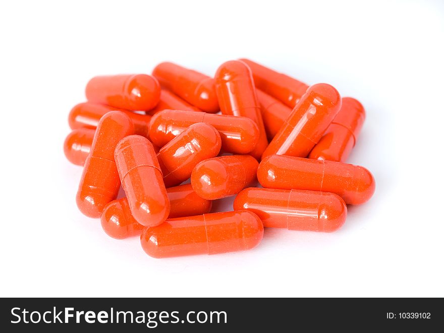 Heap of red pills capsules or drugs on white background. Heap of red pills capsules or drugs on white background