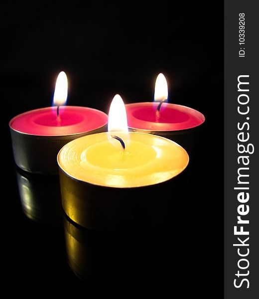 Colorful candles isolated on black background