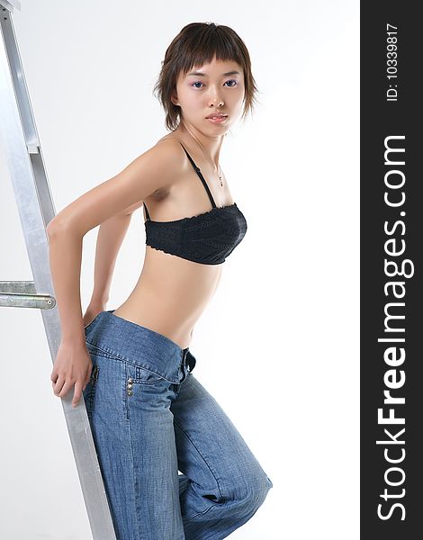 Studio portrait of a beautiful young Asian woman wearing a dress and heels in profile, her face turned toward the viewer. Isolated on a white background. Studio portrait of a beautiful young Asian woman wearing a dress and heels in profile, her face turned toward the viewer. Isolated on a white background.