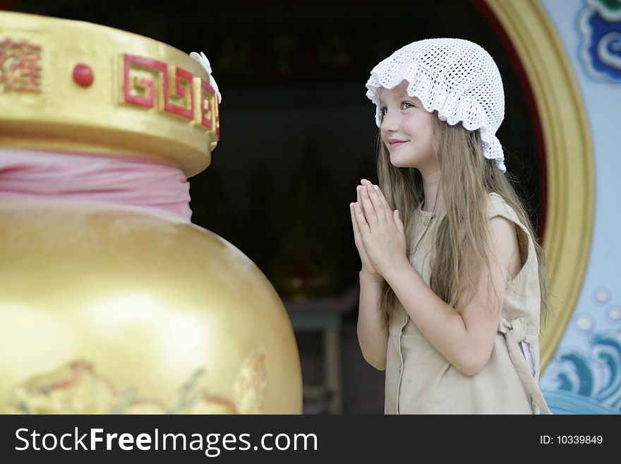 Little girl making a wish in Chineese temple