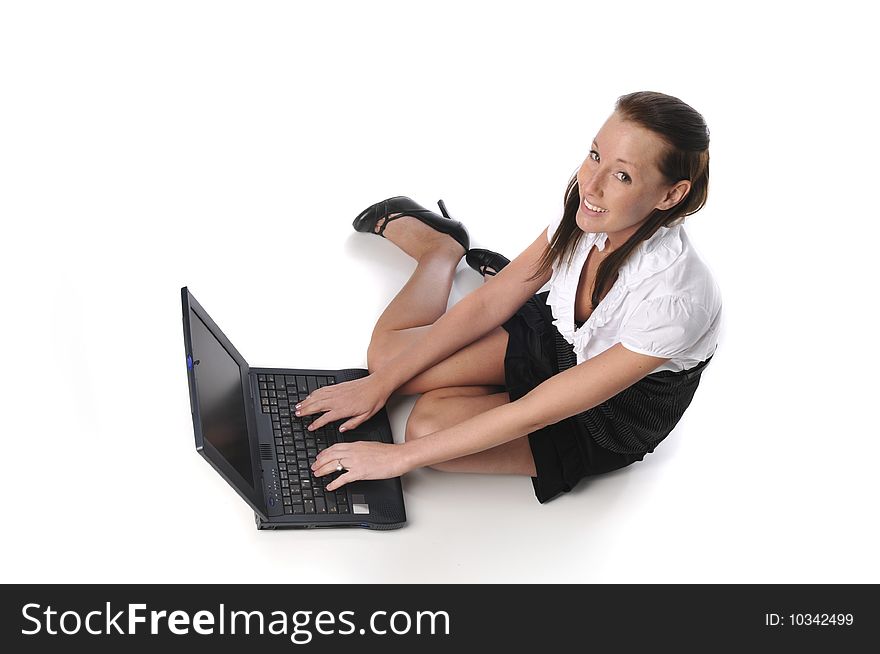 Young woman typing on a laptop sitting on the ground. Young woman typing on a laptop sitting on the ground