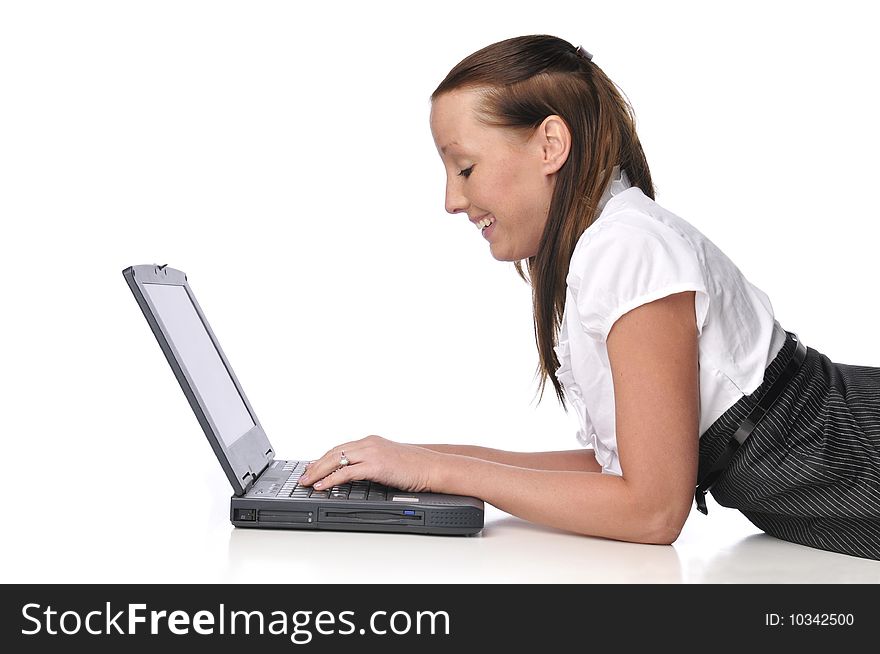 Young woman typing on a laptop and lying on the ground. Young woman typing on a laptop and lying on the ground