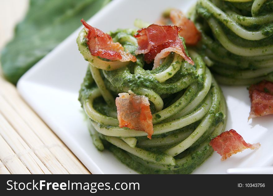 A meal of italian spaghetti with spinach and ham. A meal of italian spaghetti with spinach and ham