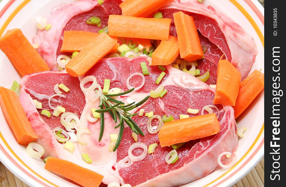 Some fresh, raw beef with vegetables in a bowl. Some fresh, raw beef with vegetables in a bowl