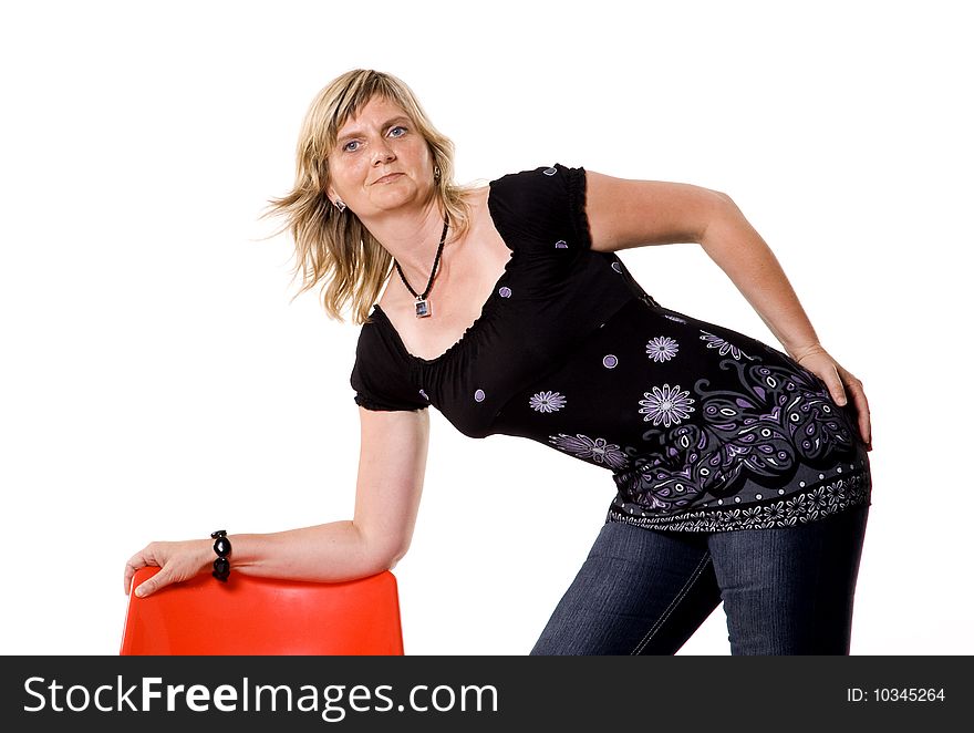 Beautiful middle aged woman posing with red chair