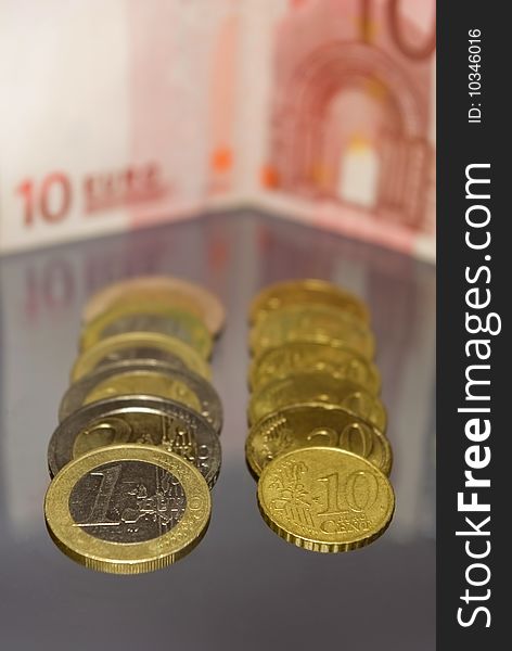 Several coins with euro banknote