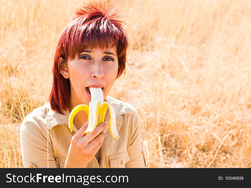Woman eats a banana outdoors. Woman eats a banana outdoors