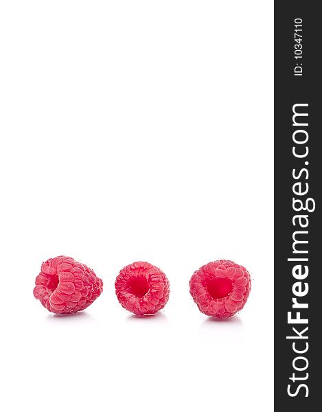 A vertical image of three fresh raspberries on white