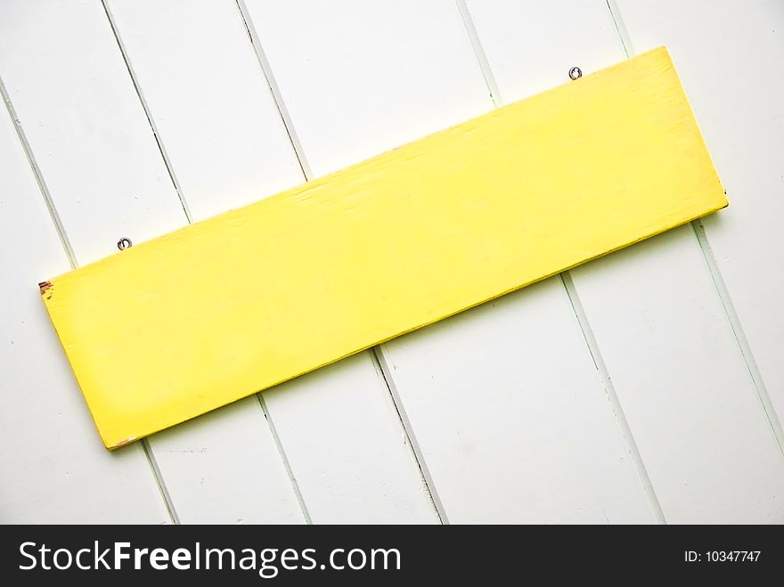 A blank sign on a wooden wall background with copy space. A blank sign on a wooden wall background with copy space.