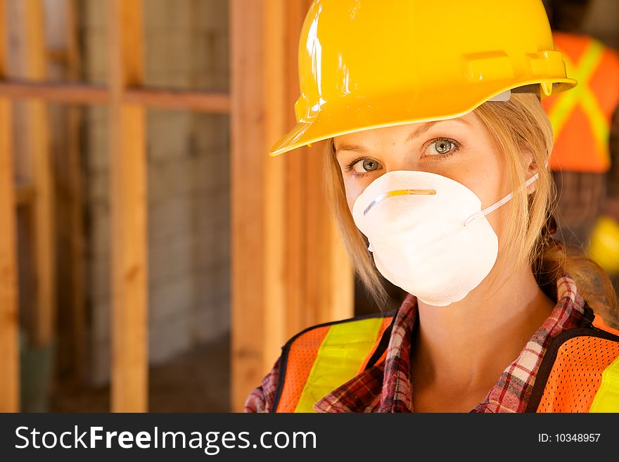 A female construction worker smiling at the camera. A female construction worker smiling at the camera