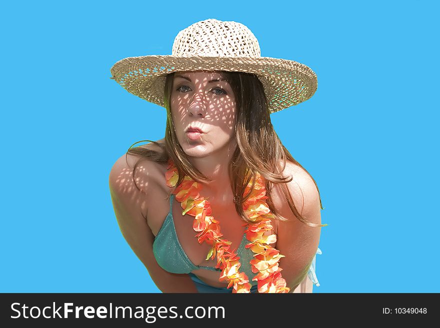 A pretty woman/girl in straw hat posing by blowing a kiss for her husband on a Hawaiian vacation. A pretty woman/girl in straw hat posing by blowing a kiss for her husband on a Hawaiian vacation.