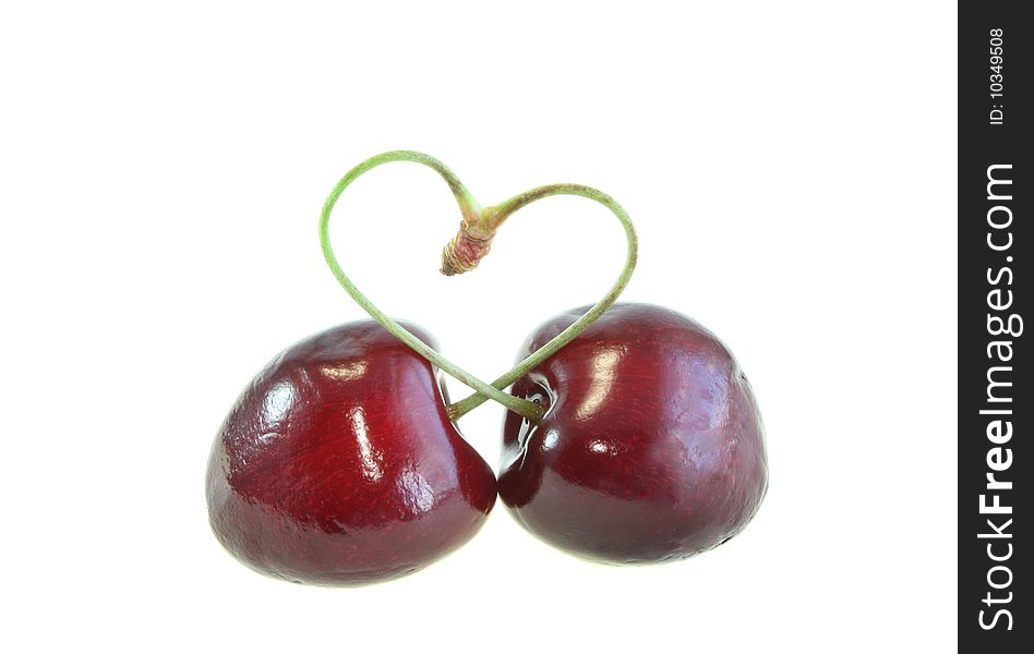 Two sweet cherries and heart on a white background, it is isolated.