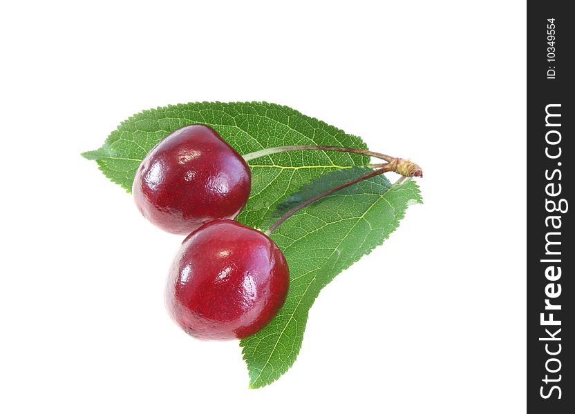 Two sweet cherries with leaves on a white background, it is isolated.