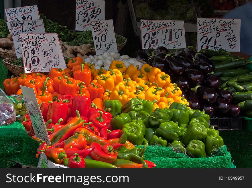 The vibrant colours of peppers and vegetables on a market stall