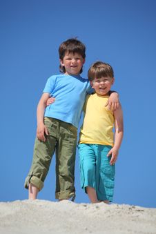 Two Boys Embrace Each Other On Sand Stock Photography