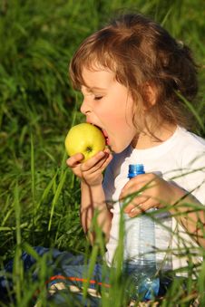 Girl With Plastic Bottle Eats Green Apple Royalty Free Stock Images