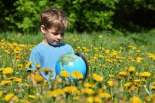 Boy With Globe On Meadow Royalty Free Stock Photography