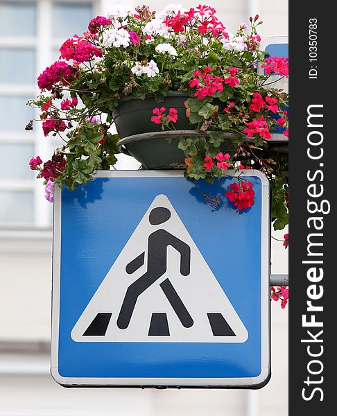Vertical picture of the crossing sign decorated with beautiful flowers