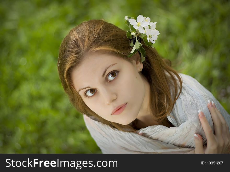 Blurred grass as background, flowers in her hair. Blurred grass as background, flowers in her hair