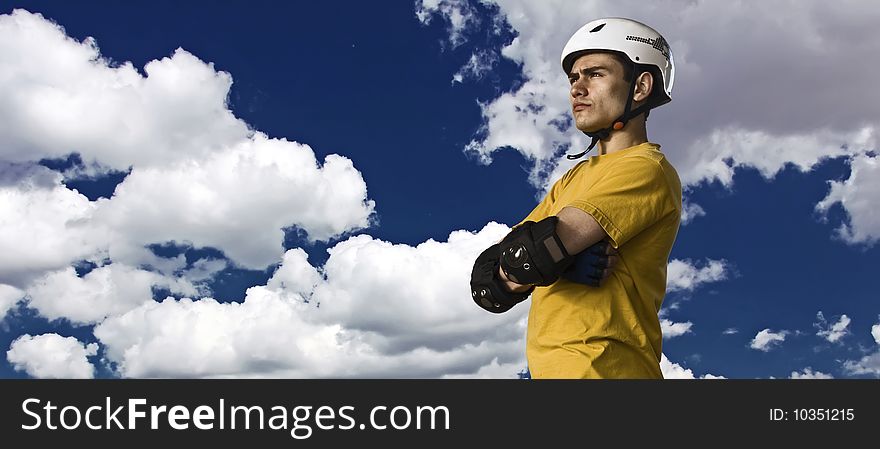 Roller with crossed hands in a protective gear with sky as background. Roller with crossed hands in a protective gear with sky as background