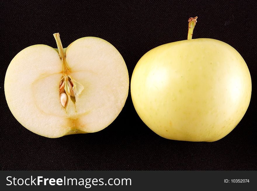 Cut green apple on a black background