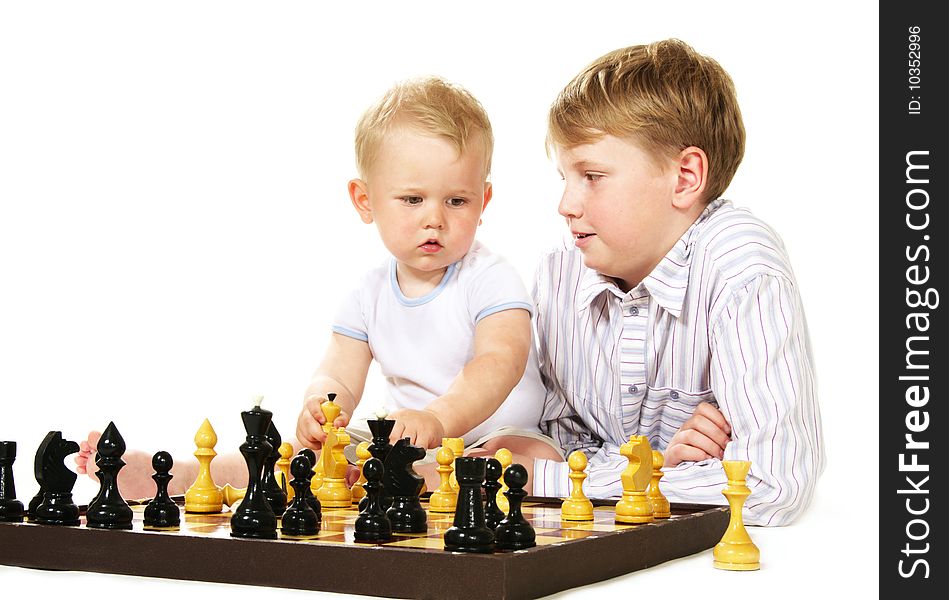 Boy teaching chess to little brother