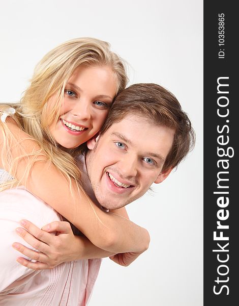 Girl embraces young man for neck behind on white