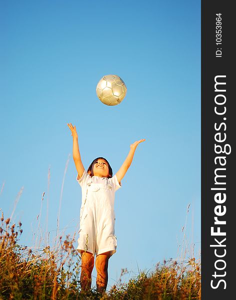 Little cute boy with ball above head in adorable place outdoor