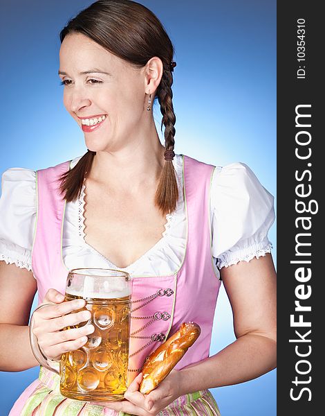 A young Bavarian girl in a Dirndl holding a beer. A young Bavarian girl in a Dirndl holding a beer.