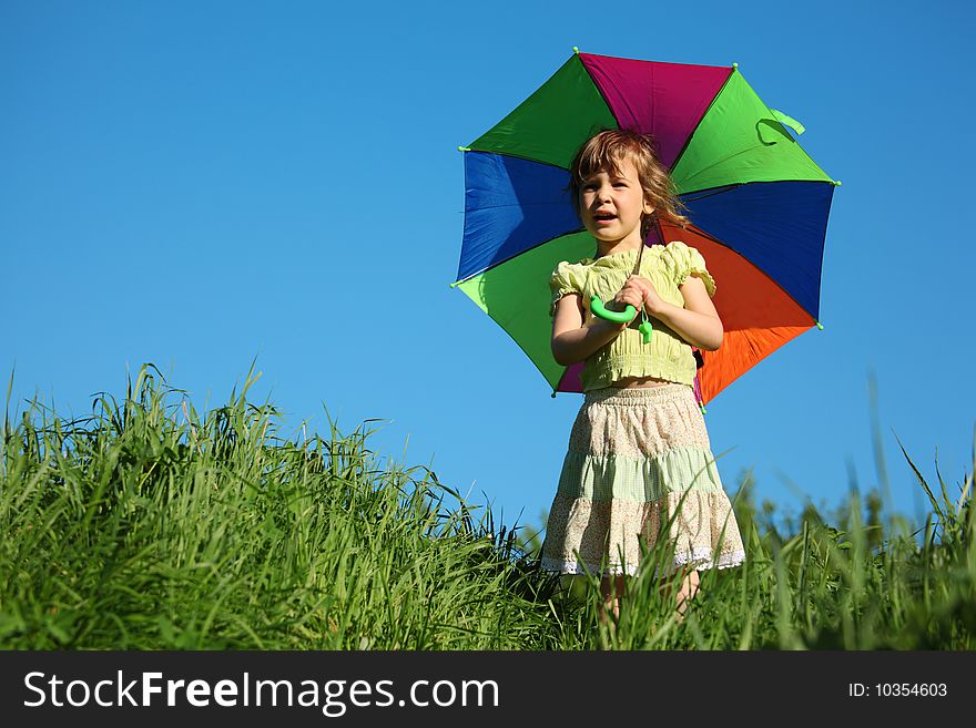 Little girl with multicoloured umbrella in grass. Little girl with multicoloured umbrella in grass