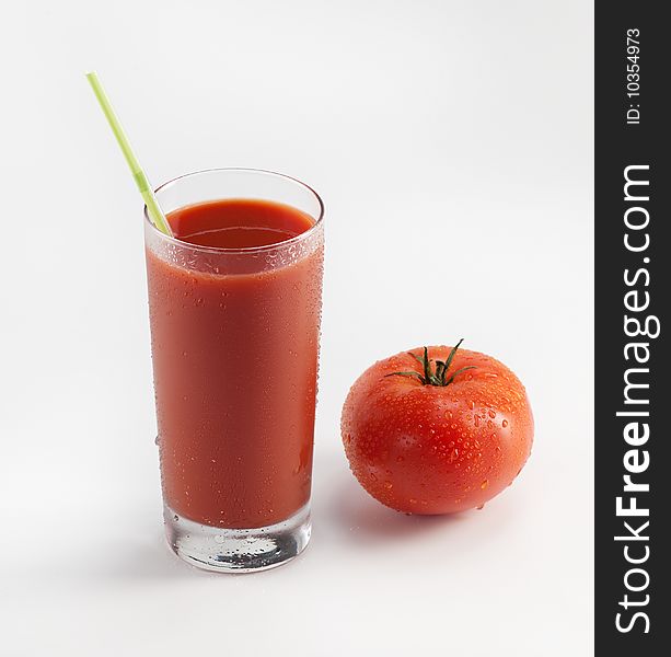 Glass with fresh tomato juice near the tomato