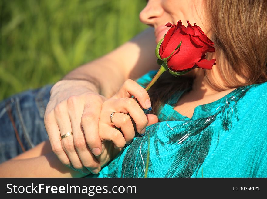 Closeup red rose and two hands